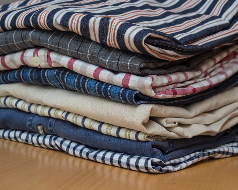 A neat stack of ironed and folded shirts